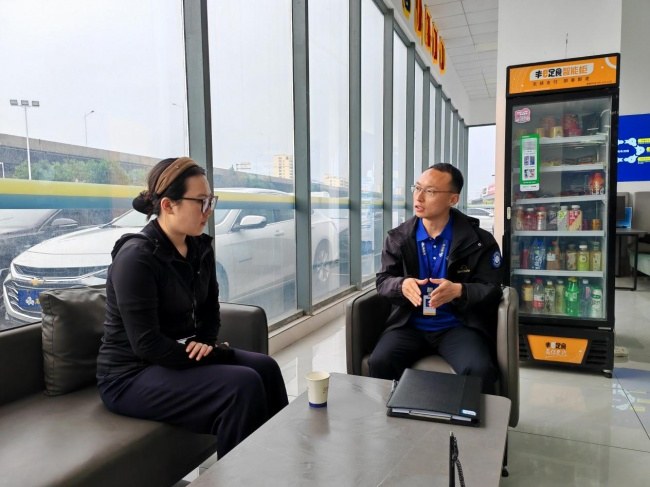 赵龙坡（右）正在给客户讲解购车方案